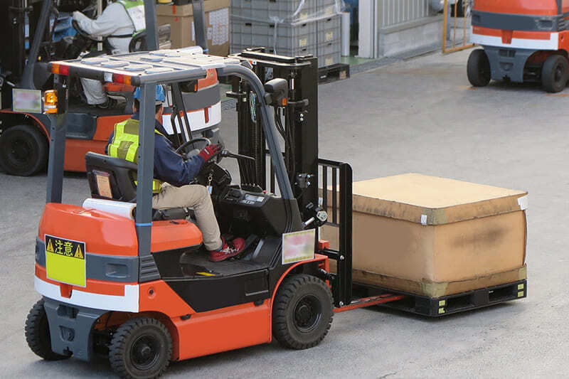 フォークリフトで荷物を運ぶ男性